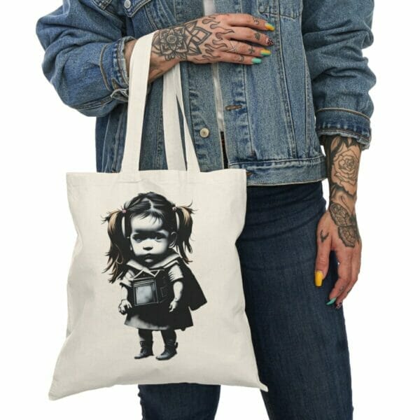 A woman showcasing the Children and Girl Street Art Natural Cotton Canvas Tote Bag with a trendy print design. A woman showcasing the Children and Girl Street Art Natural Cotton Canvas Tote Bag with a trendy print design.
