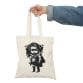 A woman holding a Children and Girl Street Art Natural Cotton Canvas Tote Bag with a girl holding a gun print design.