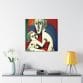 The captivating "Mother's Love Cubism Art Canvas" is displayed on a white wall above a sleek console, which is decorated with items like a vase of flowers, books, and a yellow lamp.
