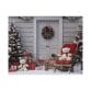 The Christmas Doorway Puzzle features a snow-dusted porch adorned with a festive wreath on the door, surrounded by decorated Christmas trees. Nestled on a wooden chair and the ground are two teddy bears and wrapped gifts.