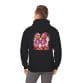 A man faces away, wearing the Halloween Street Pumpkin Men Unisex Heavy Blend™ Hooded Sweatshirt with a graphic of two pink pumpkin-headed astronauts amid Halloween-themed elements.