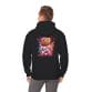 A man wears the Halloween Pumpkin Man Unisex Heavy Blend™ Hooded Sweatshirt, featuring a graphic of an astronaut with a pumpkin head and colorful paint splashes on the back.