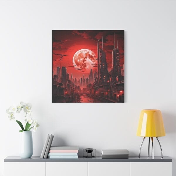 Blood Moon Over Ruins — Dystopian Cityscape Canvas, Stretched 1.25", hangs on a white wall above a cabinet with a yellow lamp, books, and a white vase of flowers. A vivid red moon dominates the futuristic cityscape art. Blood Moon Over Ruins — Dystopian Cityscape Canvas, Stretched 1.25", hangs on a white wall above a cabinet with a yellow lamp, books, and a white vase of flowers. A vivid red moon dominates the futuristic cityscape art.