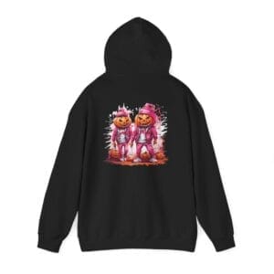The Halloween Street Pumpkin Men Unisex Heavy Blend™ Hooded Sweatshirt features two pumpkin-headed figures in pink outfits with a paint splatter background on a black hoodie.