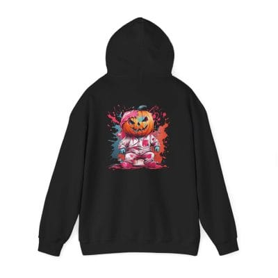 The Halloween Pumpkin Man Unisex Heavy Blend™ Hooded Sweatshirt features a black hoodie with a vibrant back graphic of a cartoon astronaut pumpkin head, surrounded by red and blue paint splashes.