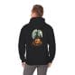 A man wears the Haunted Halloween Night Unisex Heavy Blend™ Hooded Sweatshirt, featuring a black hoodie with a pumpkin, bats, haunted house, and full moon graphic on the back.